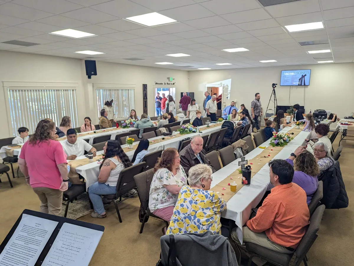 People gathered at long tables inside the church for a shared meal.