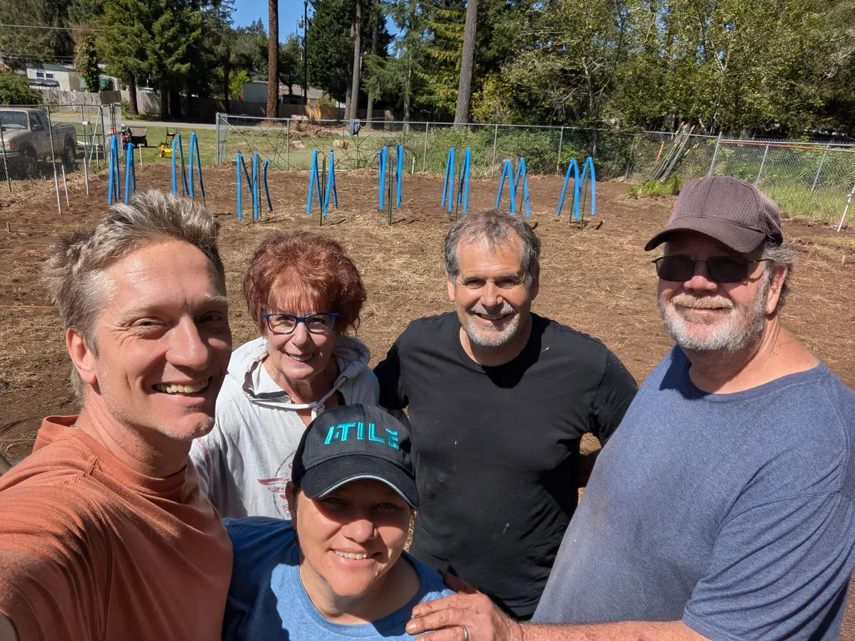 Five people smiling together in the church garden.